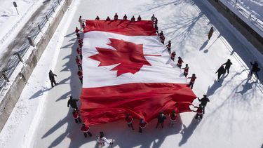 Jóvenes patinadores extienden una bandera canadiense en el Canal Rideau como parte de la conmemoración del 60mo aniversario de la bandera nacional, el viernes 14 de febrero de 2025 en Ottawa. (Adrian Wyld/The Canadian Press vía AP)
