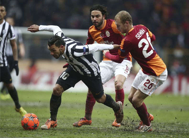 El jugador de Galatasray, Semih Kaya, derecha, disputa un bal&oacute;n con el jugador de la Juventus, Carlos Tevez, en un partido por la Liga de Campeones el mi&eacute;rcoles, 11 de diciembre de 2013, en Estambul. (AP Photo)