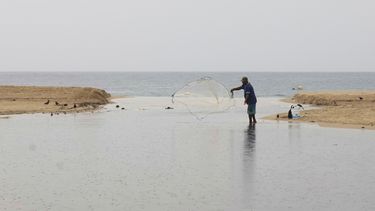 Un pescador arroja su red antes de la llegada del huracán Erick, el miércoles 18 de junio de 2025, en Puerto Escondido, en el estado de Oaxaca, en el sur de México. (AP Foto/Luis Alberto Cruz)