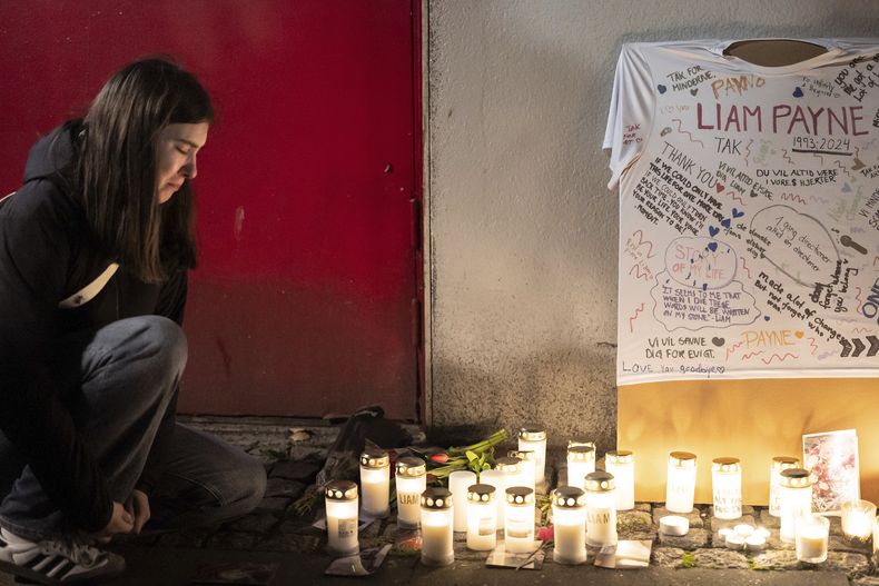 Una joven junto a un altar improvisado para el fallecido cantante Liam Payne en el Foro de Copenhague, el jueves 17 de octubre de 2024. (Emil Nicolai Helms/Ritzau Scanpix vía AP)