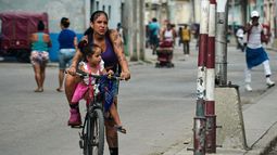Una mujer lleva a una niña en bicicleta en La Habana, Cuba, el viernes 8 de mayo de 2026. (Foto AP/Ramón Espinosa)