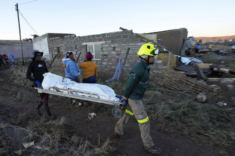ARCHIVO – Rescatistas transportan a una persona en una bolsa de cadavers después de que las inundaciones arrasaran el área en Mthatha, Sudáfrica, el jueves 12 de junio de 2025. (AP Foto/Themba Hadebe, Archivo)