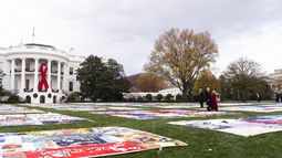 El presidente Joe Biden y la primera dama Jill Biden caminan hacia edredones para conmemorar el Día Mundial de la Lucha contra el Sida, el domingo 1 de diciembre de 2024, en Washington. (AP Foto/Manuel Balce Ceneta)