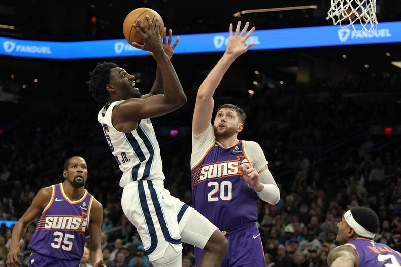 Vince Williams Jr. (5), de los Grizzlies de Memphis, dispara a la canasta sobre la marca defensiva del pívot Jusuf Nurkic (20), de los Suns de Phoenix, durante la segunda mitad del juego de baloncesto de la NBA, el domingo 7 de diciembre de 2024, en Phoenix. (AP Foto/Rick Scuteri)