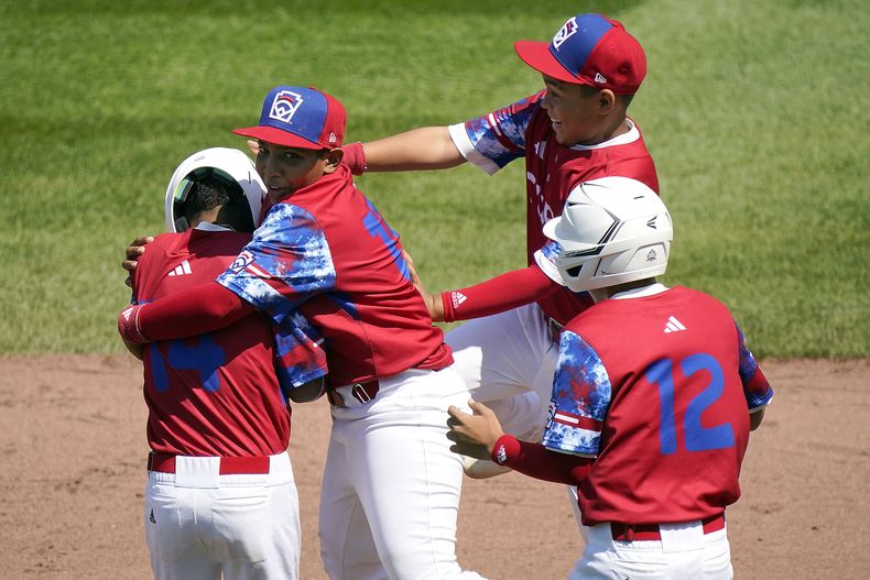 Luis Gurriel (izquierda), de Cuba, es felicitado por Didier Castillo (15), Edgar Torrez y Liusban Sánchez (12) en el juego del sábado 19 de agosto de 2023, ante Australia, en la Serie Mundial de Pequeñas Ligas (AP Foto/Tom E. Puskar)