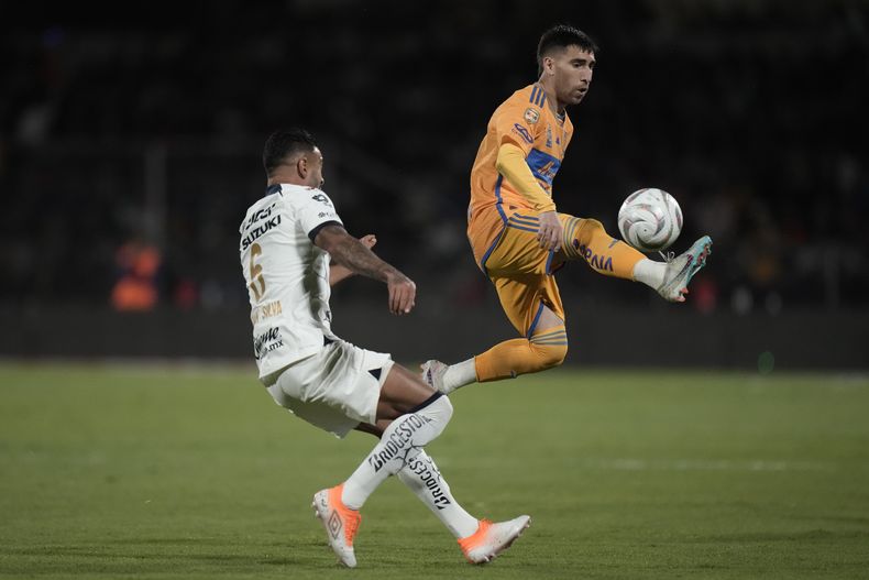 El jugador de Tigres Fernando Gorriaran, a la derecha, controla el balón frente al brasileño Nathan Silva, de Pumas, durante el partido de ida de la semifinal del fútbol mexicano, el jueves 7 de diciembre de 2023, en Ciudad de México. (AP Foto/Eduardo Verdugo)