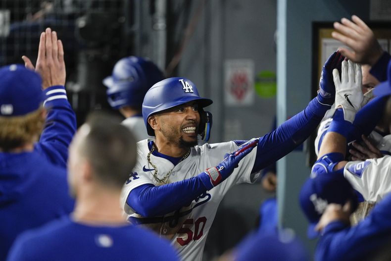 Mookie Betts, de los Dodgers de Los Ángeles, recibe la felicitación de sus compañeros tras un jonrón ante los Gigantes de San Francisco, el martes 2 de abril de 2024 (AP Foto/Ryan Sun)