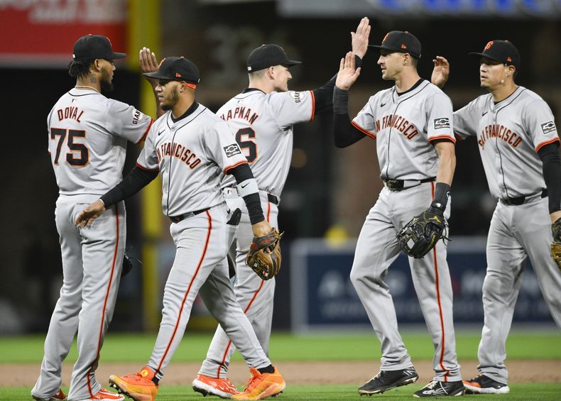 Los jugadores de los Gigantes de San Francisco chocan los cinco después de que los Gigantes vencieron a los Padres de San Diego en un juego de béisbol, el sábado 30 de marzo de 2024, en San Diego. (AP Foto/Denis Poroy)