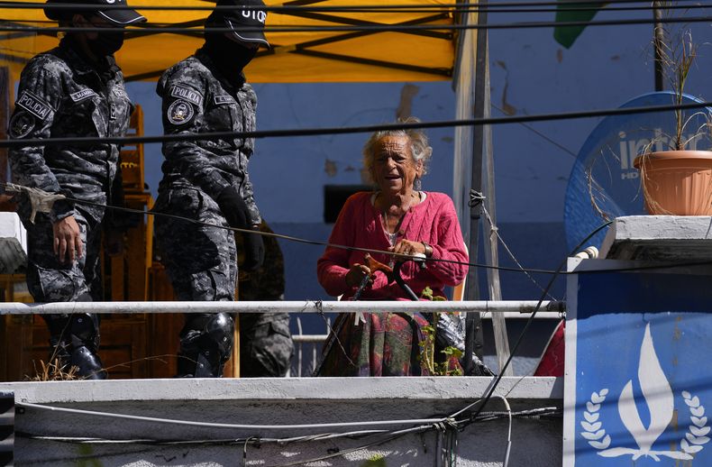 Policías junto a la activista de derechos humanos Amparo Carvajal en la azotea de su antigua oficina en la Asamblea Permanente de Derechos Humanos de Bolivia, APDHB, en La Paz, Bolivia, el jueves 20 de julio de 2023. Carvajal ingresó al edificio el 11 de julio y no ha salido, durmiendo en la terraza en un intento por recuperar su puesto luego de que acusara al partido gobernante de destituirla como presidenta de la APDHB para tomar el control de la organización. (Foto AP/Juan Karita)