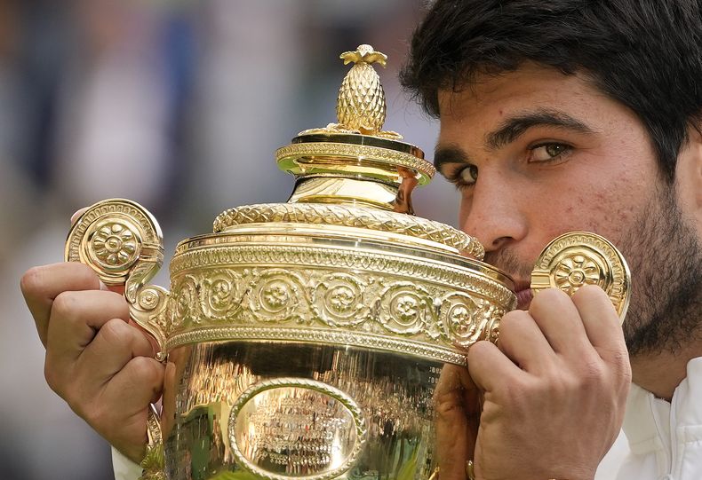 ARCHIVO - Foto del 16 de julio del 2024, el español Carlos Alcaraz celebra con el trofeo al vencer a Novak Djokovic en la final de Wimbledon. (AP Foto/Kirsty Wigglesworth, File)