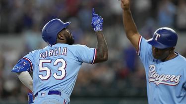 Adolis Garcia (53), de los Rangers de Texas, y el coach de tercera base Tony Beasley, derecha, celebran después del cuadrangular solitario de García en la octava entrada del juego de béisbol en contra de los Marlins de Miami, el domingo 6 de agosto de 2023, en Arlington, Texas. (AP Foto/Tony Gutierrez)