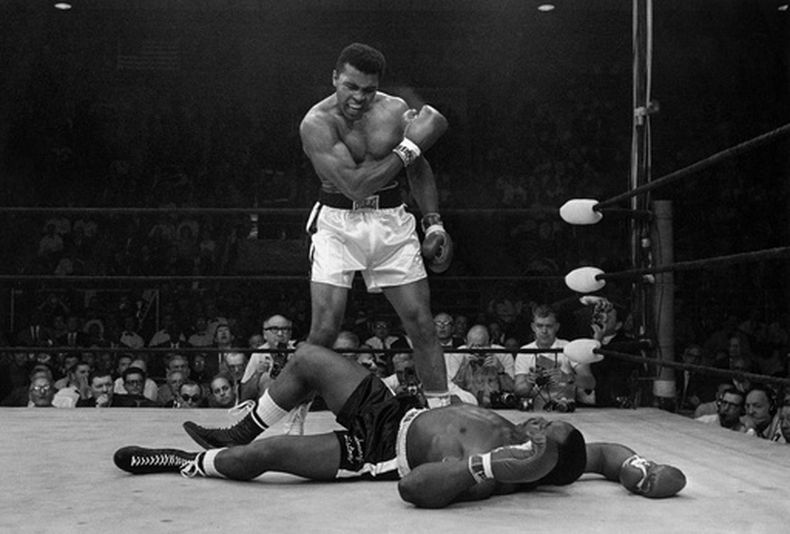 ARCHIVO - El campeón de peso pesado Muhammad Ali se para sobre el retador caído Sonny Liston, gritando y gesticulando poco después de derribar a Liston con un derechazo corto y certero a la mandíbula el 25 de mayo de 1965, en Lewiston, Maine. (Foto de archivo de AP/John Rooney)