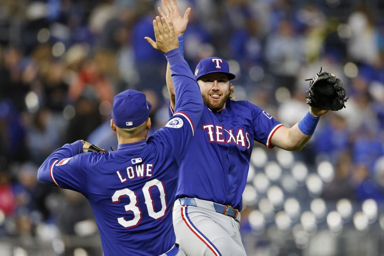Nathaniel Lowe (30) y Davis Wendzel, a la derecha, de los Rangers de Texas, celebran al final del partido de béisbol contra los Reales de Kansas City en Kansas City, Missouri, el sábado 4 de mayo de 2024. (AP Foto/Colin E. Braley)