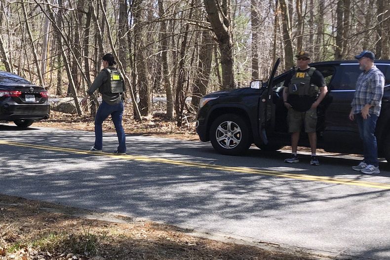 Una persona con un chaleco del FBI camina por una carretera el jueves 13 de abril de 2023, en North Dighton, Massachusetts. El FBI detuvo a un miembro de la Guardia Nacional Aérea de Massachusetts en relación con la filtración de información militar altamente confidencial sobre la guerra de Ucrania. (AP Foto/Jennifer McDermott)