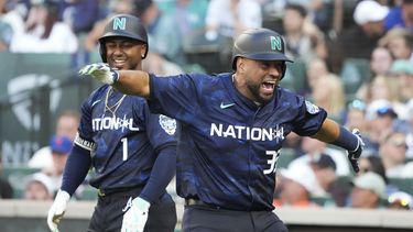 El venezolano Elías Díaz, de los Rockies de Colorado, festeja su jonrón de dos carreras con Ozzie Albies, de los Bravos de Atlanta, el martes 11 de julio de 2023 (AP Foto/Ted S. Warren)
