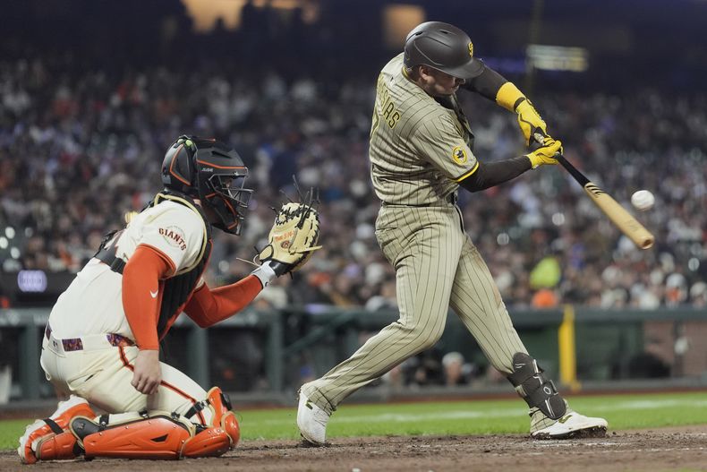 José Iglesias, derecha, de los Padres de San Diego, batea un elevado de sacrificio que llevó al plato a Jake Cronenworth durante la 10ma entrada del juego de béisbol de Grandes Ligas frente a los Gigantes de San Francisco, el lunes 2 de junio de 2025. (AP Foto/Jeff Chiu)