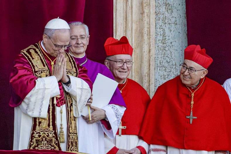 El recién elegido papa León XIV, antes el cardenal Robert Francis Prevost, aparece con el maestro de ceremonias y arzobispo Diego Giovanni Ravelli, el cardenal Pietro Parolin, y el cardenal Vinko Puljić en la logia central de la basílica de San Pedro del Vaticano, poco después de ser elegido como 267mo pontífice de la Iglesia católica de Roma, el jueves 8 de mayo de 2025. (AP Foto/Domenico Stinellis)