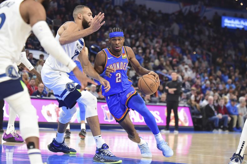 Shai Gilgeous-Alexander, del Thunder de Oklahoma City, elude a Rudy Gobert, de los Timberwolves de Minnesota, en el partido del martes 26 de diciembre de 2023 (AP Foto/Kyle Phillips)