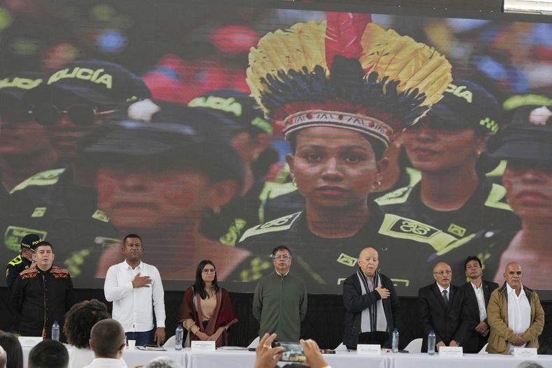 El presidente de Colombia, Gustavo Petro (centro), espera la interpretación del himno nacional durante una reunión con delegados de los Comuneros del Sur, una facción disidente del Ejército de Liberación Nacional (ELN), para discutir las conversaciones de paz en curso en Pasto, Colombia, el sábado 5 de abril de 2025. (Foto AP/Fernando Vergara)