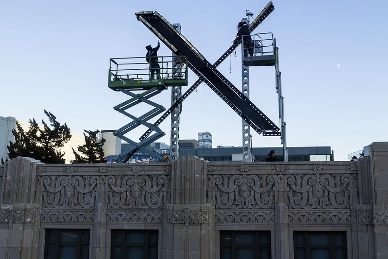 Operarios instalan un cartel con una X en lo alto de un edificio del centro de San Francisco que alberga la sede de la red social antes conocida como Twitter, renombrada ahora X por su propietario, Elon Musk, el 28 de julio de 2023. (AP Foto/Noah Berger)