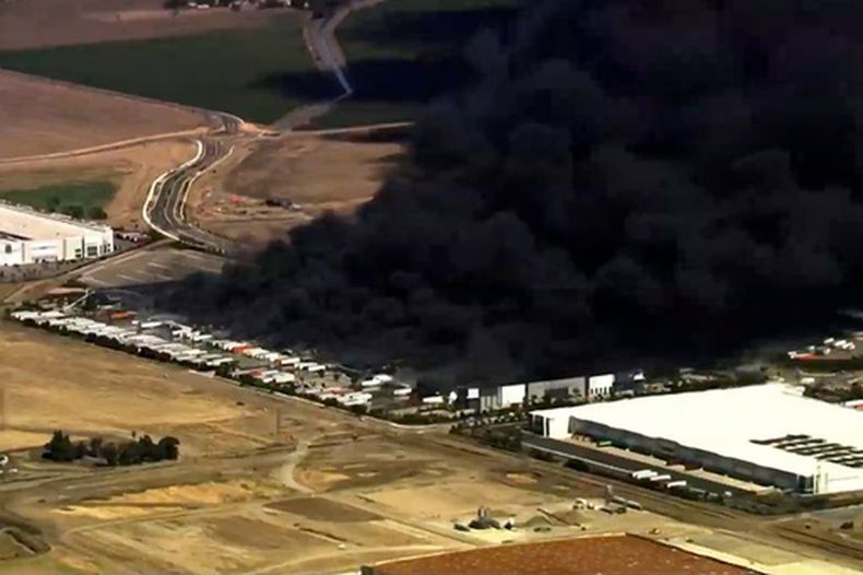 Esta imagen, obtenida de una toma aérea en video, muestra una columna de humo negro que se eleva hacia el cielo tras un incendio en un almacén de equipos médicos en Tracy, California, el jueves 11 de junio de 2026. (KGO vía AP)