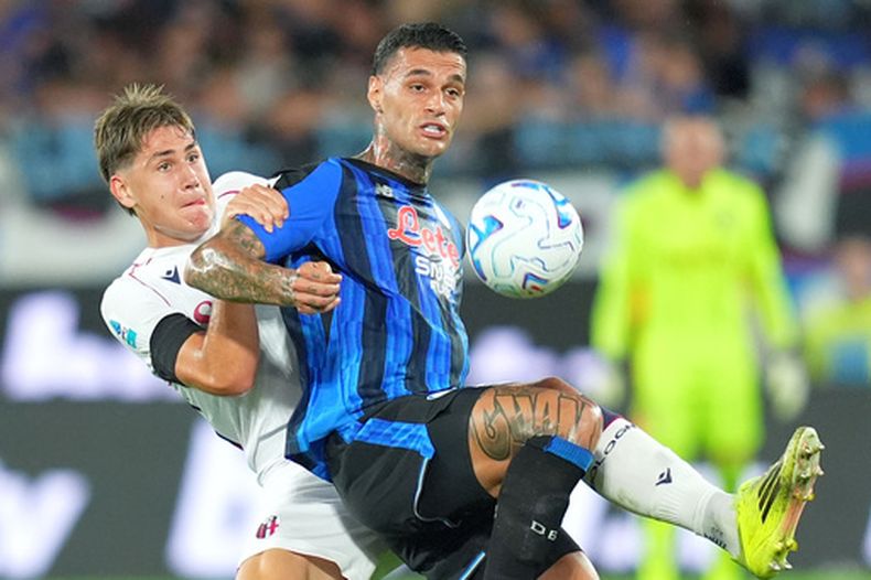 El delantero del Atalanta, Gianluca Scamacca (derecha), disputa el balón con el defensa del Bolonia, Eivind Helland (izquierda), durante el partido de fútbol de la Serie A entre el Atalanta y el Bolonia en Bérgamo, Italia, el lunes 31 de agosto de 2026. (Spada/LaPresse vía AP)