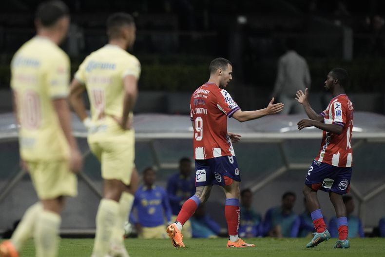 Leo Bonatini (centro), del Atlético San Luis, festeja con Vitinho, tras anotar ante el América en la vuelta de los cuartos de final de la Liga MX, el sábado 13 de mayo de 2023, en el Estadio Azteca (AP Foto/Eduardo Verdugo)