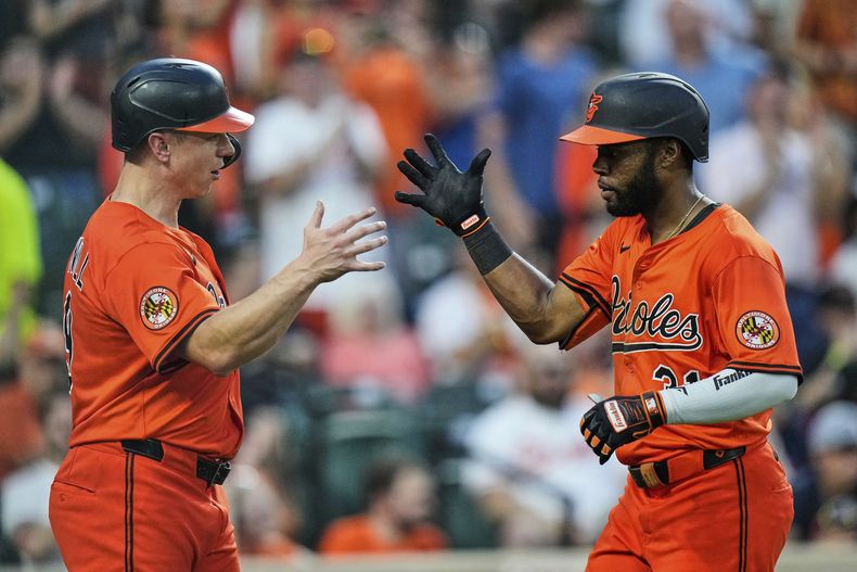 Cedric Mullins de los Orioles de Baltimore celebra con su compañero Tyler ONeill tras batear un jonrón de tres carreras en la cuarta entrada ante los Rockies de Colorado el sábado 26 de julio del 2025. (AP Foto/Stephanie Scarbrough)