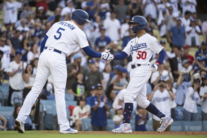 Mookie Betts de los Dodges de Los Ángeles celebra con Freddie Freeman tras pegar un jonrón en la primera entrada del juego ante los Angelinos de Los Ángeles el sábado 8 de julio del 2023. (AP Foto/Kyusung Gong)