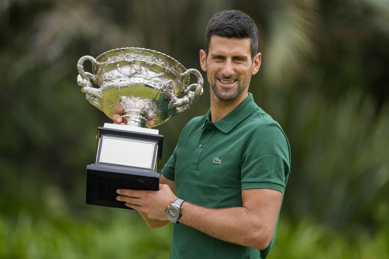 ARCHIVO - Foto del 30 de enero del 2023, el serbio Novak Djokovic sostiene el trofeo tras ganar el Abierto de Australia al superar al griego Stefanos Tsitisipas. El sábado 27 de mayo del 2023, Djokovic se prepara para ganar su 23mo título de Grand Slam en el Abierto de Francia, que no contará con Rafael Nadal. (AP Foto/Mark Baker, Archivo)