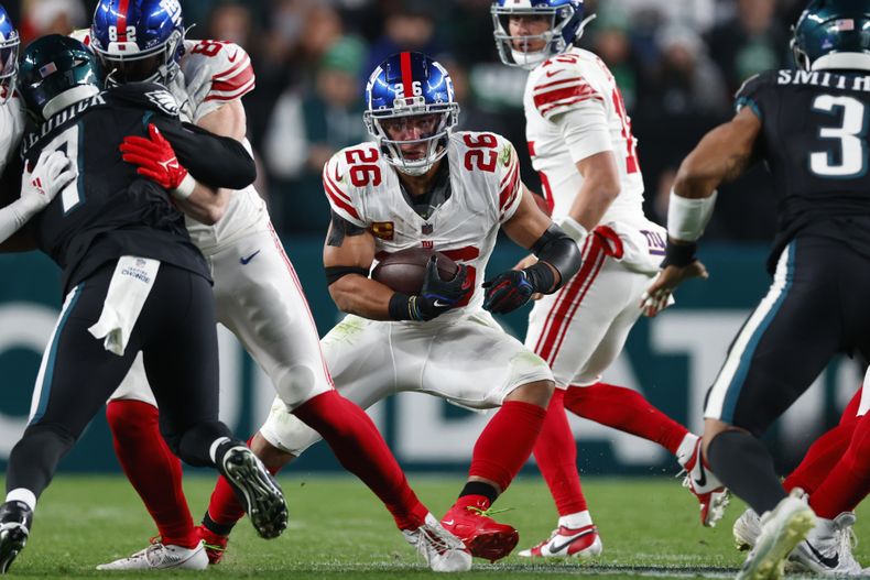 ARCHIVO - El running back Saquon Barkley (26), de los Gigantes de Nueva York, en acción en contra de los Eagles de Filadelfia durante un partido de la NFL, el lunes 25 de diciembre de 2023, en Filadelfia. Según fuentes de AP, Barkley llegó a un acuerdo con los Eagles de Filadelfia por tres años el lunes 11 de marzo, pero el acuerdo será oficial el miércoles 3 de marzo de 2023, con el inicio de la agencia libre. (AP Foto/Rich Schultz, Archivo)