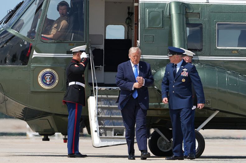 El presidente Donald Trump camina desde el helicóptero presidencial con el coronel de la Fuerza Aérea Christopher M. Robinson, en la Base Aérea Andrews en Maryland, el 4 de agosto del 2026. (AP foto/Mark Schiefelbein)