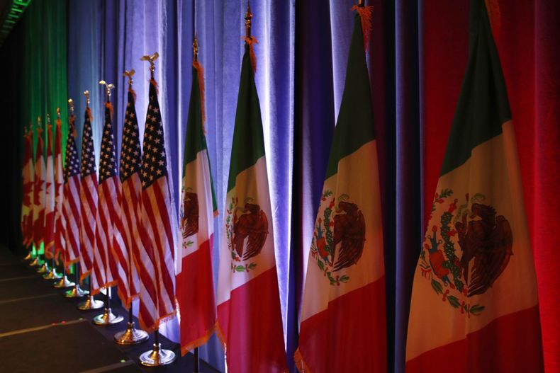 ARCHIVO - Las banderas nacionales de Canadá, desde la izquierda, de Estados Unidos y de México colocadas sobre un escenario para una conferencia de presa en las renegociaciones del tratado de libre comercio de América del Norte en Washington, el 16 de agosto de 2017. (AP Foto/Jacquelyn Martin, Archivo)