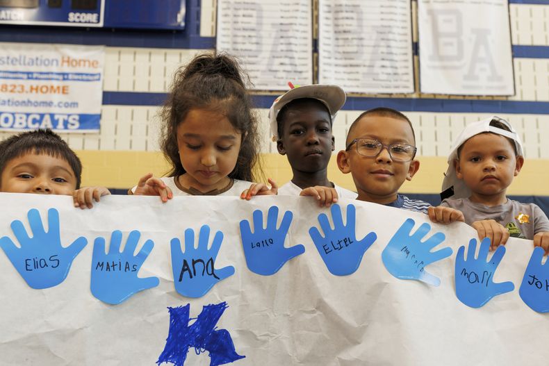 Asistentes al campamento de Verano LASOS sostienen un Proyecto de arte en la secundaria Bel Air en Bel Air, Maryland, el jueves 24 de julio de 2025. (AP Foto/KT Kanazawich)