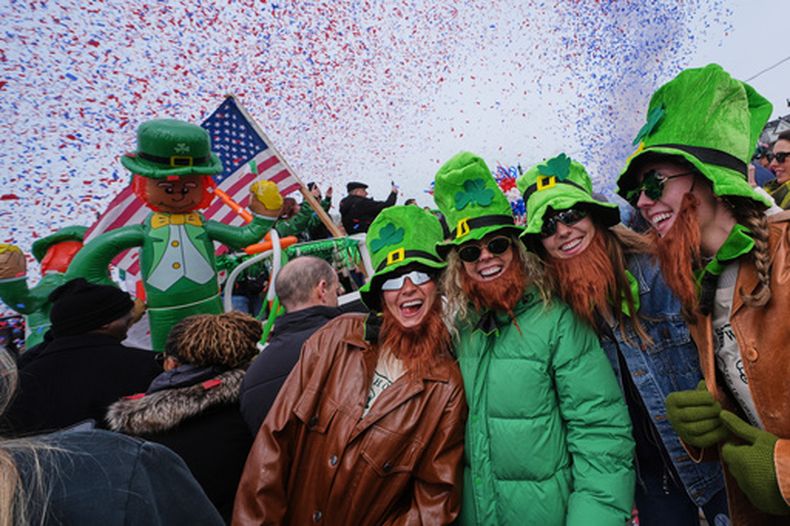 Mujeres con sombreros de duende y barbas falsas sonríen durante el desfile anual del Día de San Patricio, el domingo 15 de marzo de 2026, en Boston. (AP Foto/Charles Krupa)