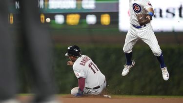 El dominicano José Ramírez, de los Guardianes de Cleveland, se barre en la intermedia sin que el torpedero de los Cachorros de Chicago, Dansby Swanson, a la derecha, logre controlar un lanzamiento del segunda base Nico Hoerner en la sexta entrada del partido en Chicago, el sábado 1 de julio de 2023. (AP Foto/Charles Rex Arbogast)