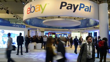 americateve | Asistentes al Mobile World Congress, el congreso mundial de tel&eacute;fonos celulares m&aacute;s grande del mundo, pasan debajo de un letrero de eBay y PayPal en Barcelona, Espa&ntilde;a, el 27 de febrero de 2013. PayPal se separar&aacute; de eBay en 201