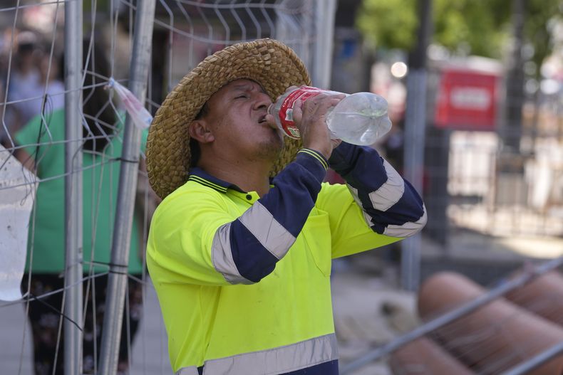 ARCHIVO - Un trabajador de carreteras hace un descanso para beber agua en Madrid, España, el lunes 18 de julio de 2022. La organización de Naciones Unidas para el empleo advirtió el lunes 22 de abril de 2024 que más del 70% de la fuerza de trabajo del mundo se verá expuesto probablemente a un calor excesivo durante sus carreras, y señaló su preocupación en alza por la exposición a la luz solar. También alertó de la polución en el aire, pesticidas y otros factores de riesgo que pueden producir problemas de salud como el cáncer. (AP Foto/Paul White, Archivo)