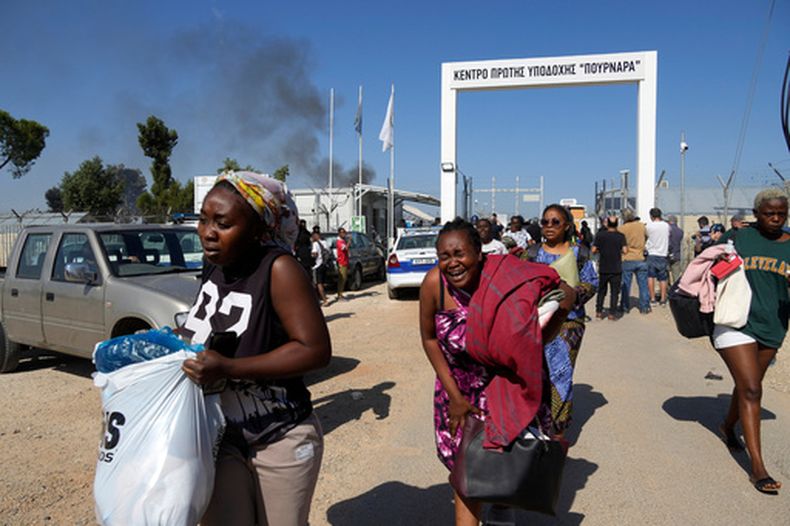 ARCHIVO - Mujeres migrantes salen del centro de acogida de migrantes de Pournara tras enfrentamientos entre grupos rivales dentro del campamento, cerca de la aldea de Kokkinotrimithia, en las afueras de Nicosia, la capital de Chipre, el viernes 28 de octubre de 2022. (Foto AP/Petros Karadjias, archivo)