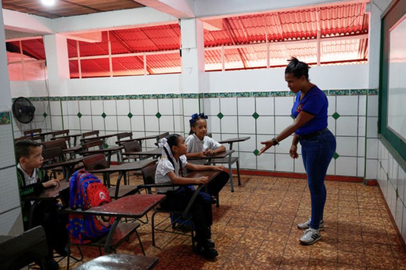 La maestra Zulimar Marcano habla con sus alumnos mientras regresan a clase por primera vez desde el terremoto en la escuela Congreso de Angostura en La Guaira, Venezuela, el lunes 14 de septiembre de 2026. (AP Foto/Ariana Cubillos)