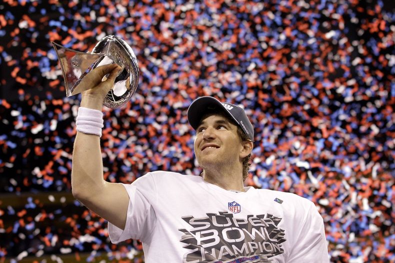 ARCHIVO - El quarterback Eli Manning de los Giants de Nueva York alza el trofeo Vince Lombardi tras la victoria 21-17 ante los Patriots de Nueva Inglaterra en el Super Bowl, el domingo 5 de febrero de 2012, en Indianápolis. (AP Foto/David J. Phillip)