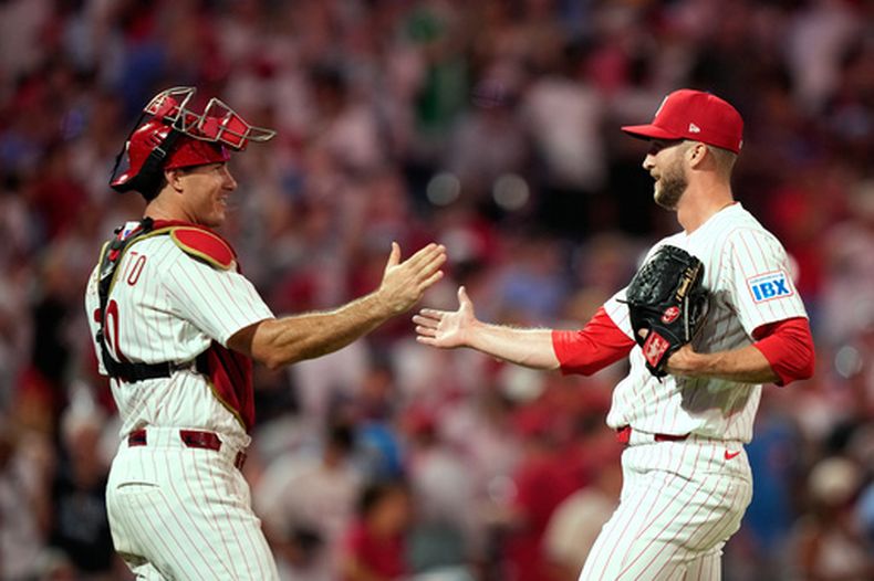 J.T. Realmuto, izquierda, y Caleb Kilian, de los Filis de Filadelfia, celebran despúes de una victoria sobre los Nacionales de Washington, el martes 4 de agosto de 2026, en Filadelfia. (AP Foto/Matt Slocum)