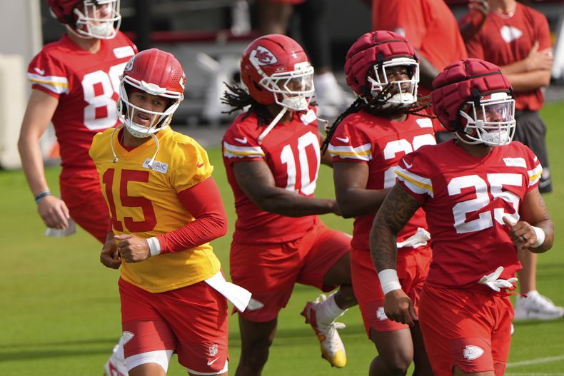 El quarterback de los Chiefs de Kansas City, Patrick Mahomes (15), corre con sus compañeros de equipo en el campo de entrenamiento de fútbol americano de la NFL el martes 22 de julio de 2025, en St. Joseph, Misuri. (AP Photo/Charlie Riedel)
