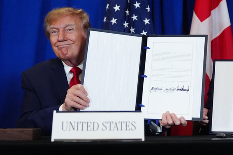 ARCHIVO - El presidente estadounidense Donald Trump muestra el documento tras firmar un acuerdo de seguridad con la primera ministra de Dinamarca, Mette Frederiksen, y el primer ministro de Groenlandia, Jens-Frederik Nielsen, durante la Asamblea General de Naciones Unidas, el 22 de septiembre de 2026, en la sede de la ONU. (Foto AP/Julia Demaree Nikhinson, archivo)