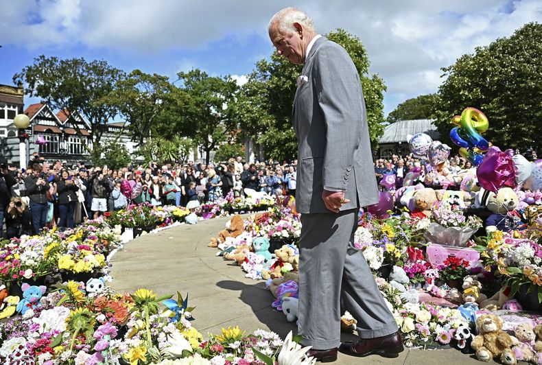 El rey Carlos III de Gran Bretaña mira ofrendas frente al Ayuntamiento de Southport, en Southport, Inglaterra, el martes 20 de agosto de 2024, mientras se reúne con miembros de la comunidad local, luego del ataque del 29 de julio en una clase de baile infantil. (Paul Ellis/Pool vía AP)