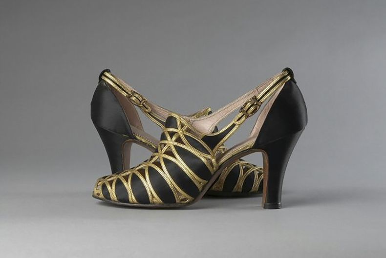 Esta imagen proporcionada por el Museo de la Ciudad de Nueva York muestra zapatos de noche de satén de seda negro y cuero en tono dorado fabricados por Delman Black en 1936. (Museum of the City of New York via AP)