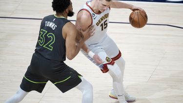 El jugador de los Nuggets de Denver Nikola Jokic, a la derecha, trata de eludir al jugador de los Timberwolves de Minnesota Karl-Anthony Towns en la primera mitad del quinto partido de su serie de primera ronda de playoffs de la NBA, el martes 25 de abril de 2023 en Denver. (AP Foto/David Zalubowski)