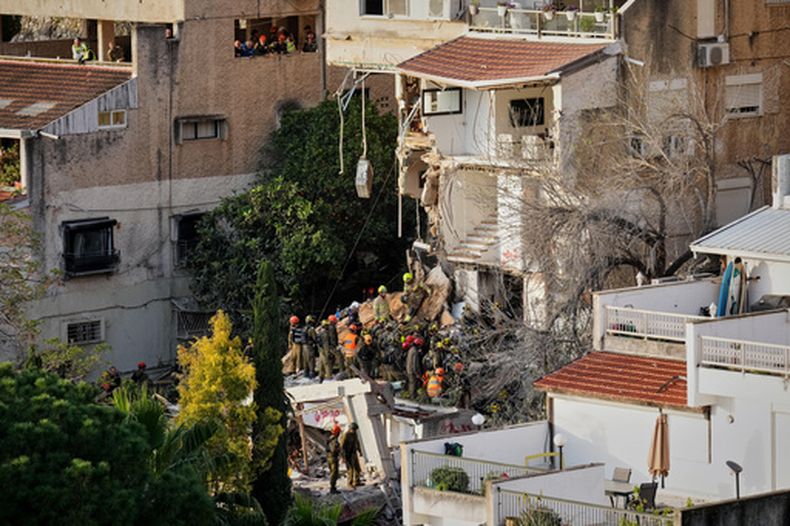 Equipos israelíes de rescate buscan desaparecidos entre los escombros de un edificio residencial alcanzado por un misil iraní el día anterior en Haifa, Israel, el lunes 6 de abril de 2026. (AP Foto/Ariel Schalit)