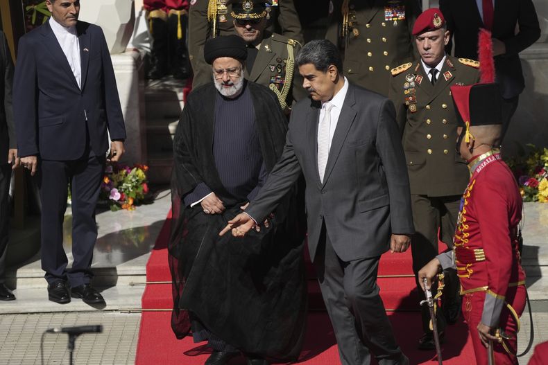 El presidente de Irán, Ebrahim Raisi, en el centro a la izquierda, camina con el presidente venezolano, Nicolás Maduro, a su llegada al palacio presidencial de Miraflores en Caracas, Venezuela, el lunes 12 de junio de 2023. (AP Foto/Ariana Cubillos)