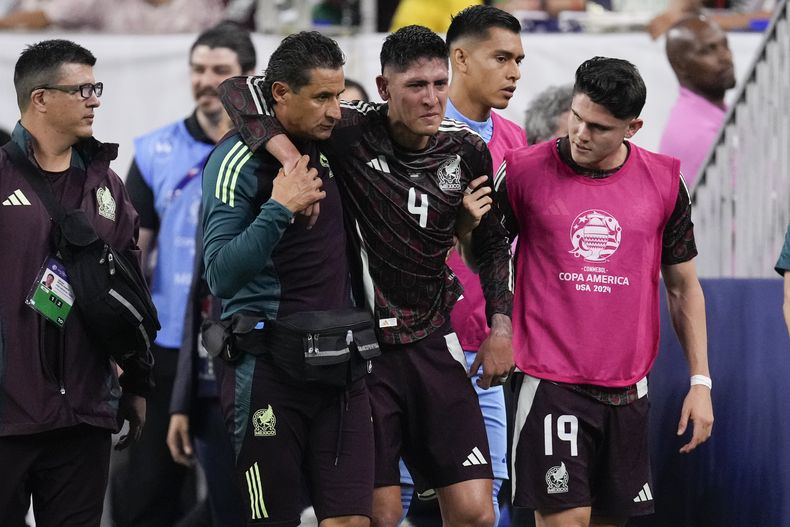 El volante mexicano Edson Álvarez (centro) se retira lesionado durante el partido contra Jamaica por el Grupo B de la Copa América, el sábado 22 de junio de 2024, en Houston. (AP Foto/Kevin M. Cox)